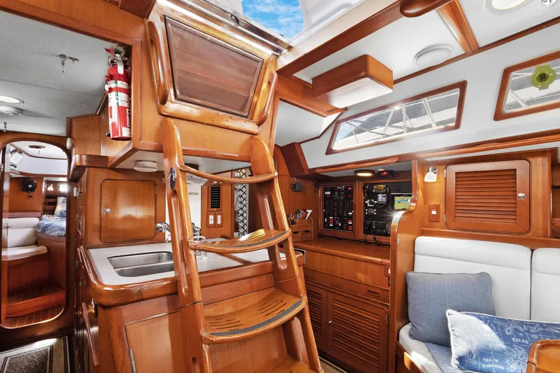 Southern Cross Yacht Photos Pics Luxurious 2004 Hylas 46 yacht interior with wooden finish, cozy seating, and navigation panel.