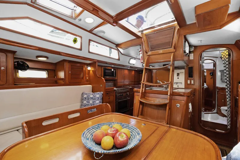 Southern Cross Yacht Photos Pics Interior of 2004 Hylas 46 yacht with wooden finish and dining area.