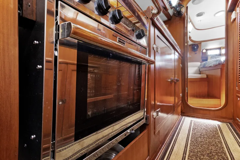 Southern Cross Yacht Photos Pics Interior of 2004 Hylas 46 yacht, featuring a sleek wooden kitchen and cozy cabin.