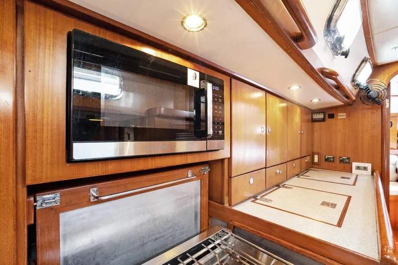 Southern Cross Yacht Photos Pics Luxurious 2004 Hylas 46 yacht kitchen with wood cabinetry and modern appliances.