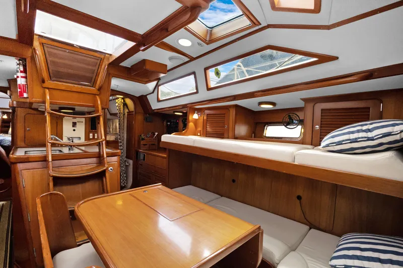 Southern Cross Yacht Photos Pics Interior of 2004 Hylas 46 yacht with wooden furnishings and cozy seating area.