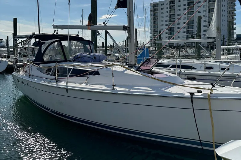 To The Gills Yacht Photos Pics 2014 Hunter 33 sailboat docked at marina with modern buildings in background.
