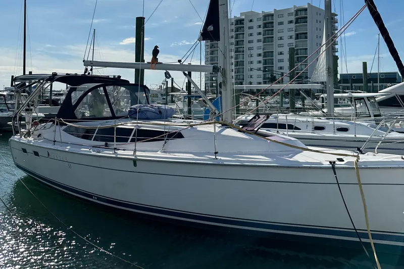 To The Gills Yacht Photos Pics 2014 Hunter 33 sailboat docked at marina with modern buildings in background.
