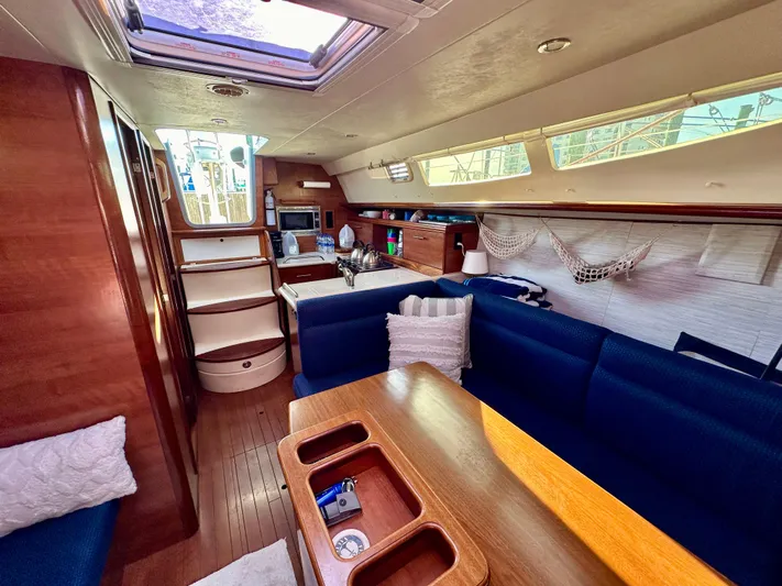 To The Gills Yacht Photos Pics Interior of a 2014 Hunter 33 sailboat with blue seating and wooden finishes.