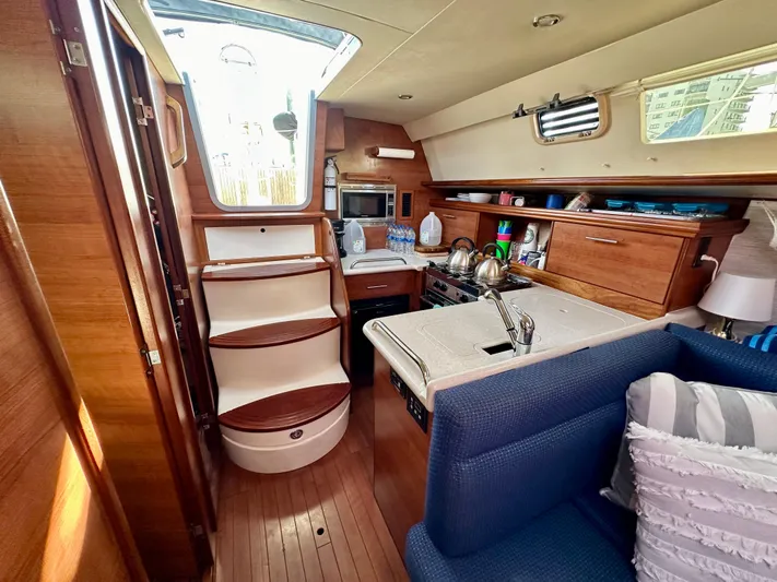 To The Gills Yacht Photos Pics Interior of a 2014 Hunter 33 sailboat with modern kitchen and seating area.