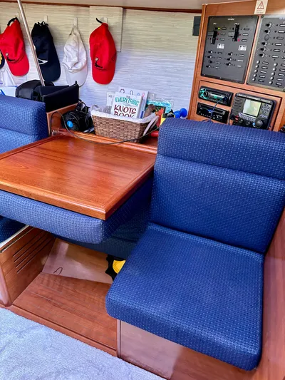 To The Gills Yacht Photos Pics Interior of 2014 Hunter 33 sailboat with blue seating and wooden table.