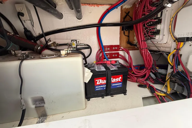  Yacht Photos Pics 2025 Pursuit OS 325 Offshore boat battery compartment with wiring and marine battery.