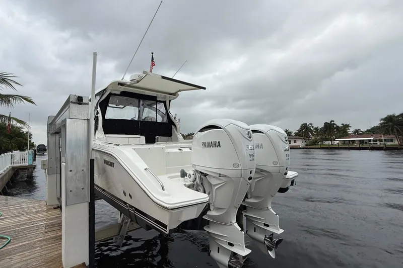  Yacht Photos Pics 2025 Pursuit OS 325 Offshore boat with twin Yamaha engines docked by a waterfront.