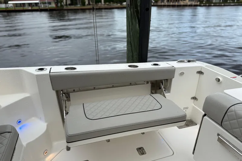  Yacht Photos Pics 2025 Pursuit OS 325 Offshore boat with foldable seating and cup holders by the water.