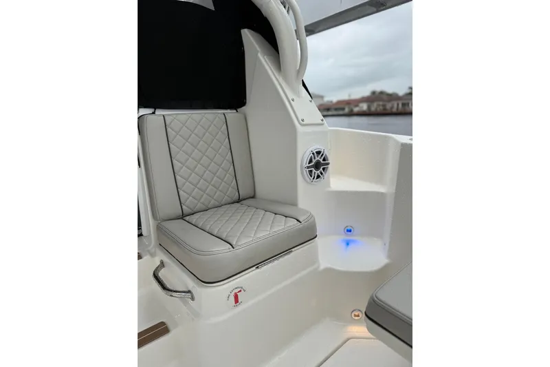  Yacht Photos Pics 2025 Pursuit OS 325 Offshore boat interior with cushioned seating and speaker.