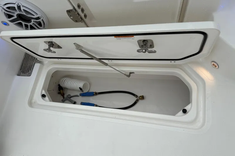  Yacht Photos Pics Storage compartment of 2025 Pursuit OS 325 Offshore boat with hoses and fittings.