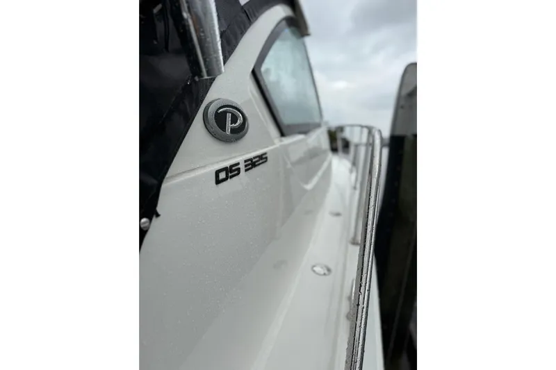  Yacht Photos Pics 2025 Pursuit OS 325 Offshore boat side view with logo and railing.