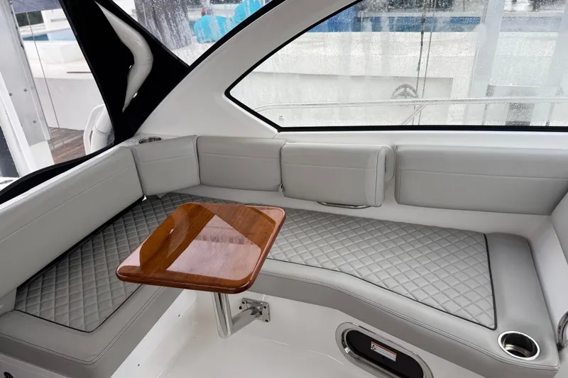  Yacht Photos Pics Luxurious interior of 2025 Pursuit OS 325 Offshore boat with quilted seating and wooden table.