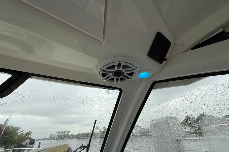  Yacht Photos Pics Interior view of 2025 Pursuit OS 325 Offshore boat with speaker and raindrop-covered windows.
