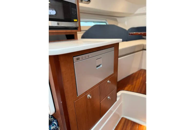  Yacht Photos Pics 2025 Pursuit OS 325 Offshore interior with microwave and wooden cabinetry.