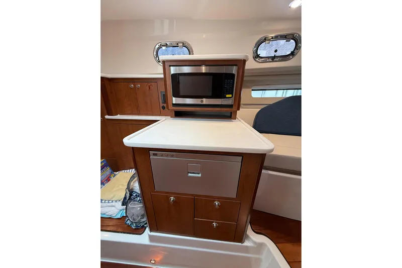  Yacht Photos Pics 2025 Pursuit OS 325 Offshore interior with microwave and storage cabinets.