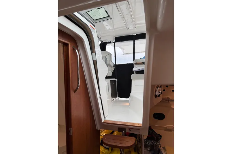  Yacht Photos Pics Interior view of 2025 Pursuit OS 325 Offshore boat, showcasing cabin and seating area.
