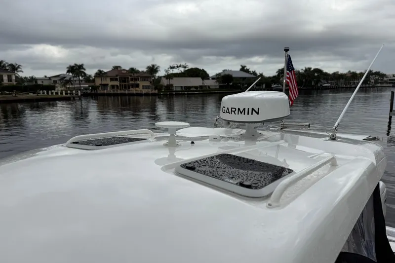  Yacht Photos Pics 2025 Pursuit OS 325 Offshore boat with Garmin radar on a cloudy waterfront.