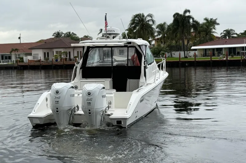  Yacht Photos Pics 2025 Pursuit OS 325 Offshore boat with twin Yamaha engines on a calm waterway.