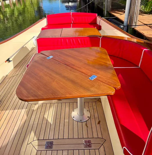 Le Ti Yacht Photos Pics 2004 Hinckley Talaria 29R boat with red cushioned seating and wooden table.