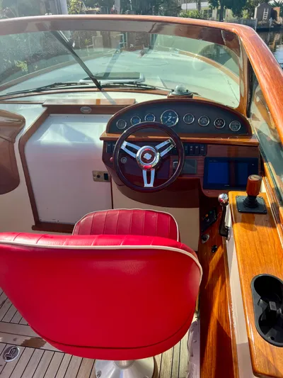 Le Ti Yacht Photos Pics 2004 Hinckley Talaria 29R boat cockpit with red captain's chair and wooden dashboard.