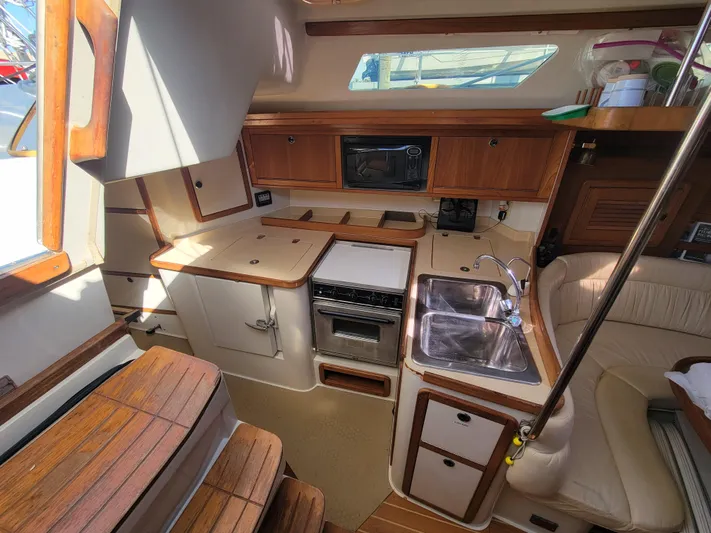 Prairie Wind Yacht Photos Pics Interior of 2003 Catalina 42 Mk2 sailboat, featuring a compact kitchen with wood accents.
