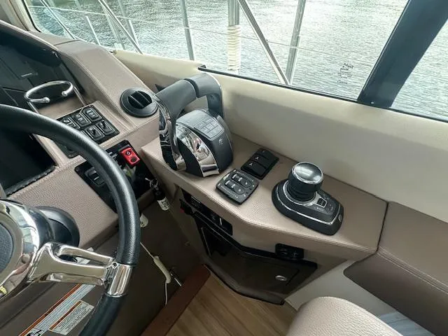  Yacht Photos Pics 2017 Regal 53 Sport Coupe helm with controls and steering wheel, docked by water.