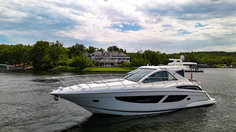  Yacht Photos Pics 2017 Regal 53 Sport Coupe yacht cruising on a scenic lake with lush greenery.