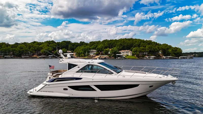  Yacht Photos Pics 2017 Regal 53 Sport Coupe yacht on a scenic lake with cloudy sky.