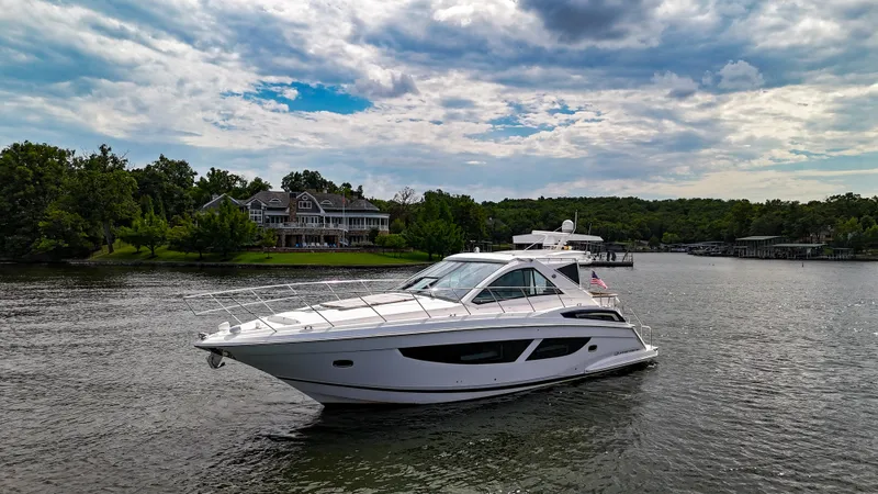  Yacht Photos Pics 2017 Regal 53 Sport Coupe yacht cruising on a scenic lake with lush greenery.