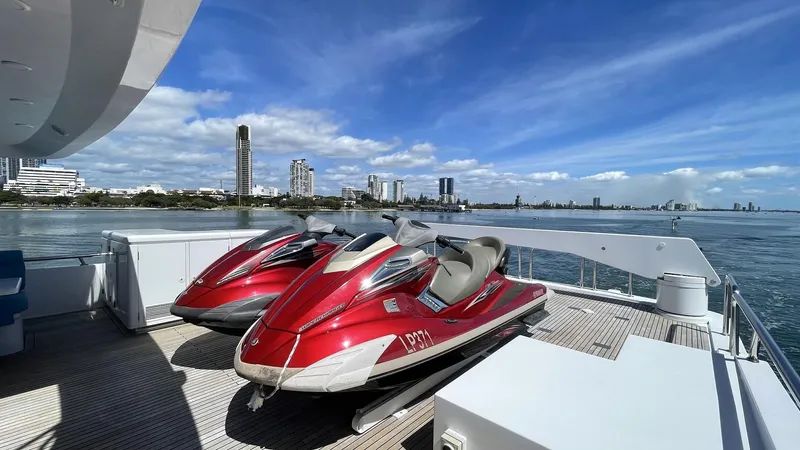 Missy B II Yacht Photos Pics Red jet skis on a 2005 Hargrave Custom Yacht deck, with city skyline and ocean view.