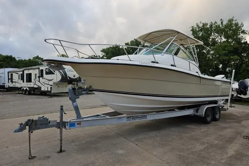 2001 Pursuit 2870 Walkaround boat on trailer, parked outdoors.