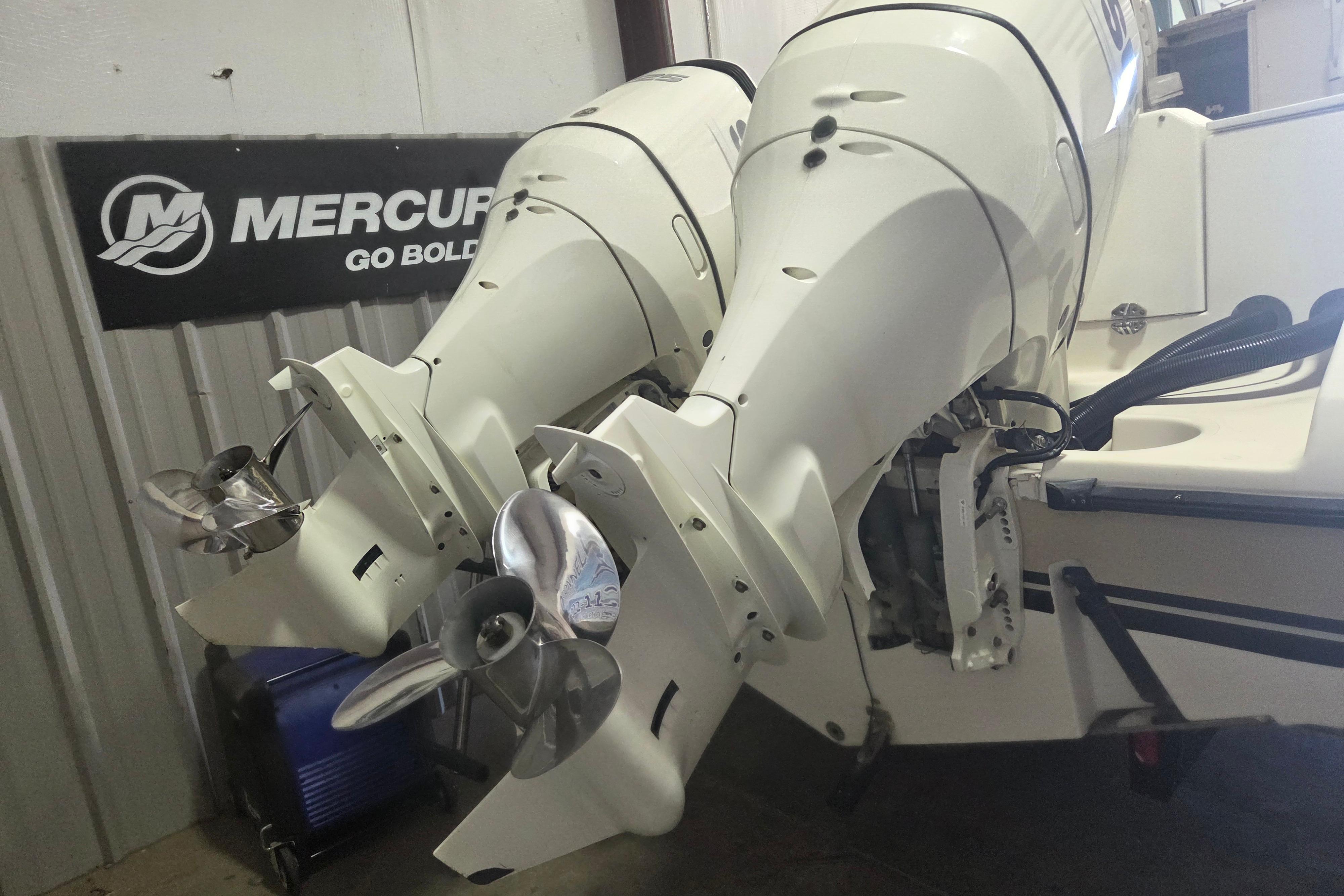 2001 Pursuit 2870 Walkaround boat with dual Mercury outboard engines in a garage setting.