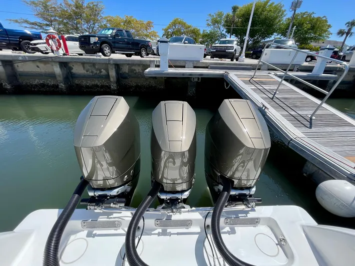 Caryali Yacht Photos Pics Triple outboard engines on a 2014 Invincible 42 Open Fisherman at a dock.