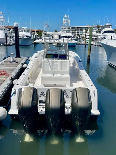 Caryali Yacht Photos Pics 2014 Invincible 42 Open Fisherman boat docked with triple outboard engines.