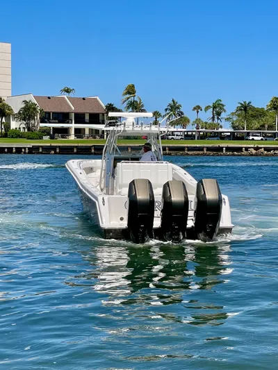 Caryali Yacht Photos Pics 2014 Invincible 42 Open Fisherman boat with triple engines on a sunny day.