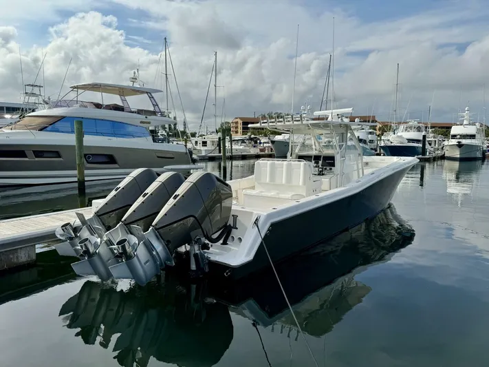 Caryali Yacht Photos Pics 2014 Invincible Open Fisherman boat docked in marina with triple outboard engines.