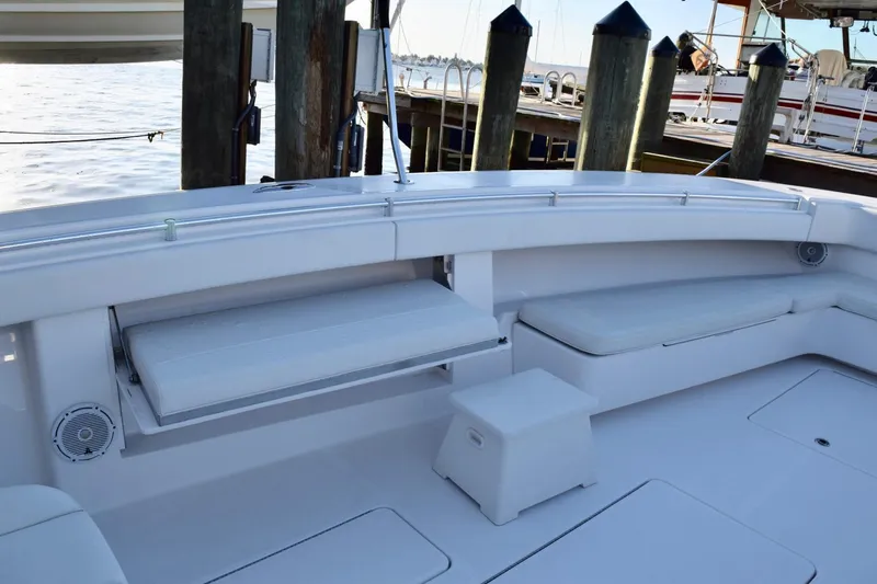 Caryali Yacht Photos Pics 2014 Invincible Open Fisherman boat interior with seating and storage, docked by wooden posts.