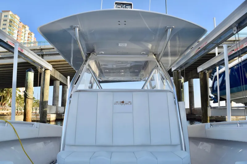Caryali Yacht Photos Pics 2014 Invincible Open Fisherman boat docked under a bridge, showcasing sleek design and spacious seating.