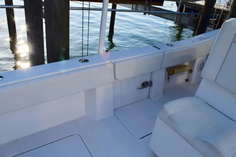 Caryali Yacht Photos Pics 2014 Invincible Open Fisherman boat interior with white seating and deck, docked by the water.