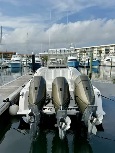 Caryali Yacht Photos Pics 2014 Invincible Open Fisherman boat docked with triple outboard engines.