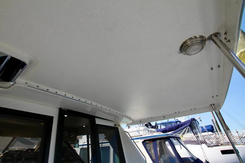  Yacht Photos Pics 2002 Bayliner 3988 boat deck with overhead light and railing, docked at marina.