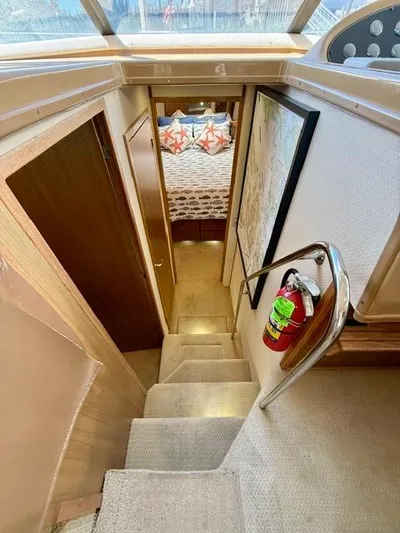  Yacht Photos Pics Stairway leading to cabin interior of 2002 Bayliner 3988 yacht, featuring cozy bedroom.