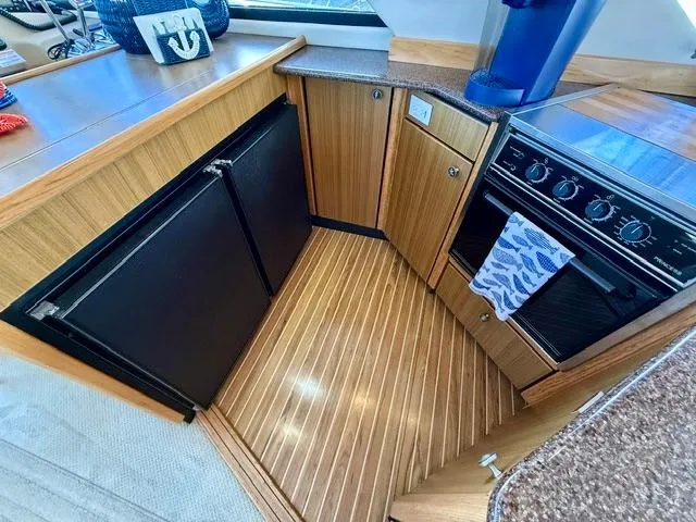  Yacht Photos Pics 2002 Bayliner 3988 yacht kitchen with wood flooring, stove, and refrigerator.