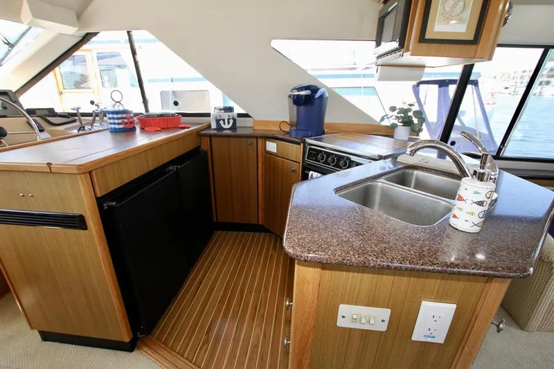  Yacht Photos Pics 2002 Bayliner 3988 yacht kitchen with modern appliances and wooden cabinetry.