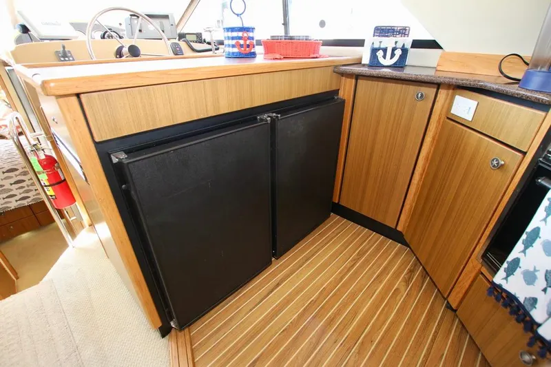  Yacht Photos Pics 2002 Bayliner 3988 yacht interior with wooden cabinetry and compact kitchen appliances.