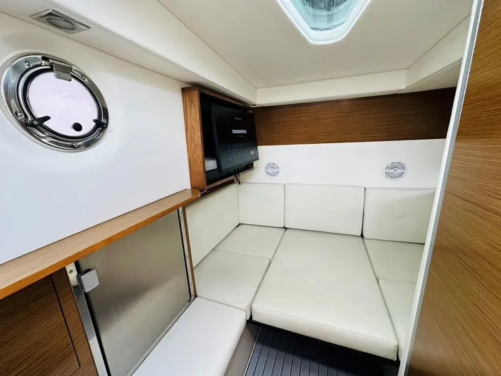  Yacht Photos Pics 2015 Cruisers Sport Series 328 cabin interior with white seating and wood accents.