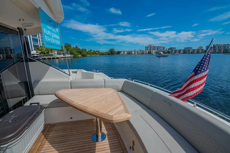 The Empire Yacht Photos Pics 2018 Sea Ray L590 yacht with a scenic waterfront view and American flag.