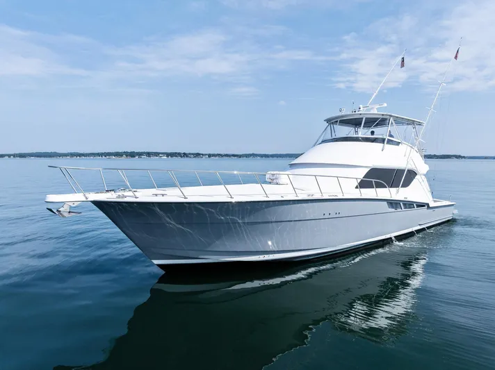 Amp'd Up Yacht Photos Pics 1999 Hatteras 60 Convertible yacht cruising on calm waters under a clear sky.