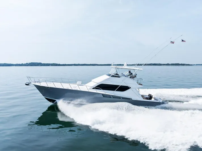 Amp'd Up Yacht Photos Pics 1999 Hatteras 60 Convertible yacht cruising on calm waters, creating a dynamic wake.